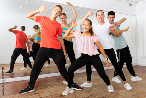 Group portrait of glad teenagers in dance studio