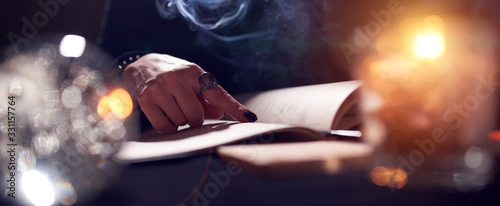 Foto Close-up of fortune-teller's hands, book of predictions, burning candle