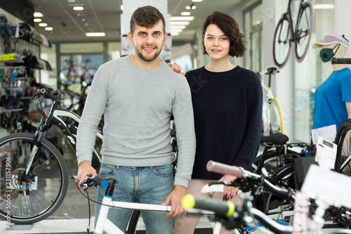 Modern couple standing with sport bicycle