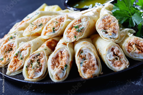 Thin crepes with cream cheese and shredded salmon photo