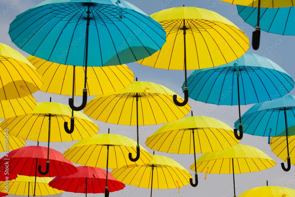 Obraz premium Colorful umbrellas background. Colorful umbrellas in the sky. Street decoration 