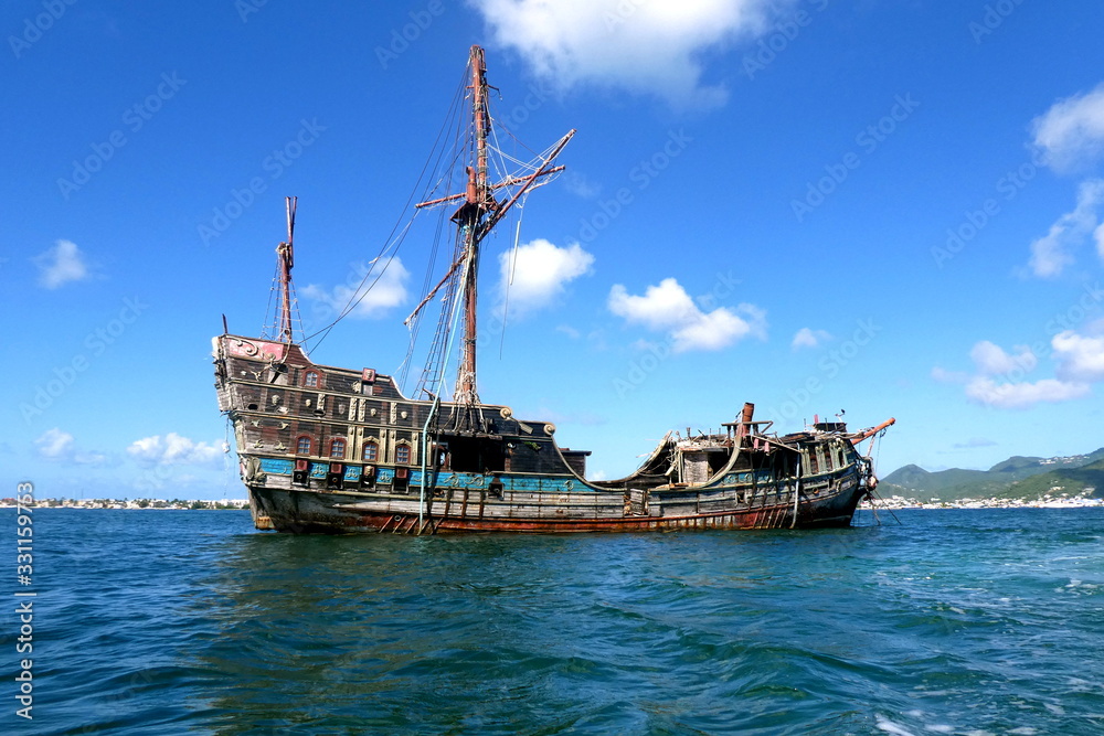 Fototapeta premium Altes Bootswrack auf dem Wasser, gekentertes Piratenschiff, Saint Martin, Karibik