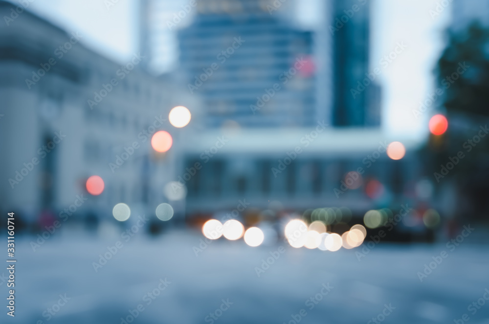 Blurred city street with traffics light bokeh and buildings background.