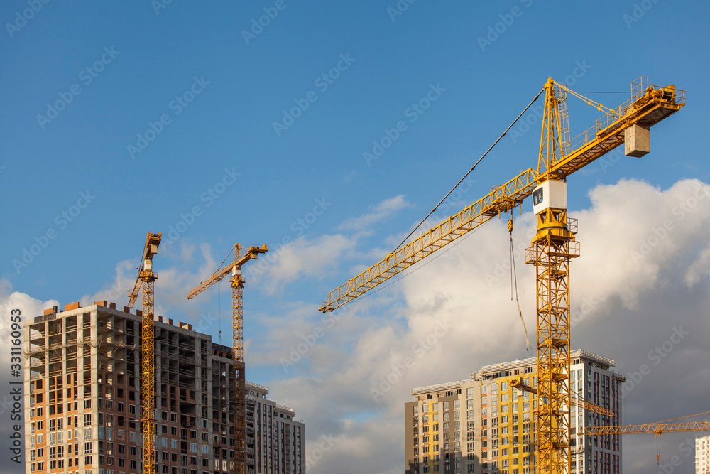 Construction site with cranes against the blue sky	