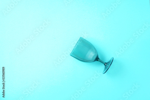 Champagne glass on blue background with copy space for text. Top view. Holiday and celebration concept.