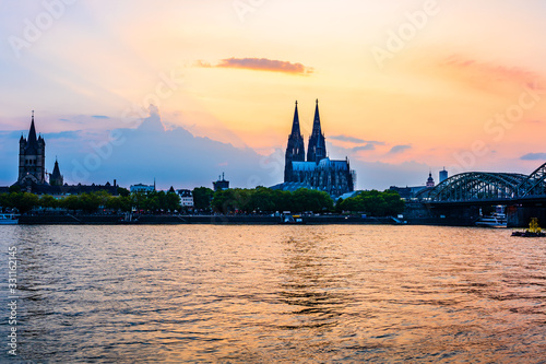 Sunset silhouette skyline landscape of the gothic Cologne Cathedra  Hohenzollern railway and pedestrian bridge  the old town and Great St Martin church on the banks of river Rhine in Cologne  Germany