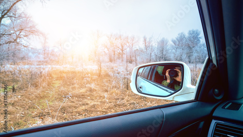 Car mirror with reflection of photographer on nature background.