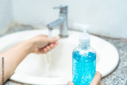 Asian washing hand by press blue alcohol sanitizer gel for protect infection and kill Novel Coronavirus  2019-nCoV  Covid-19 virus  bacteria and germs..
