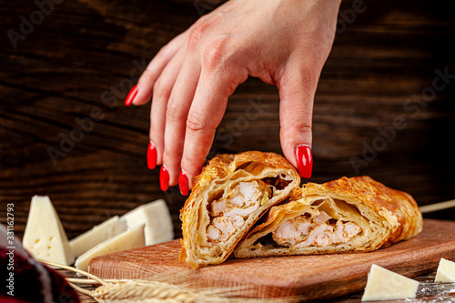 Baking Georgian cuisine. Puff pastry pie with chicken and cheese. The dish lies on a wooden table. background image, copy space text