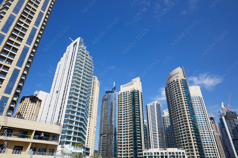 Obraz premium Dubai Marina skyscrapers, low angle view in a sunny day, clear blue sky in Dubai