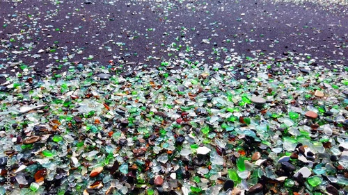 glass beach. many small fragments of glass carved by the sea lie on the beach. environmental pollution.