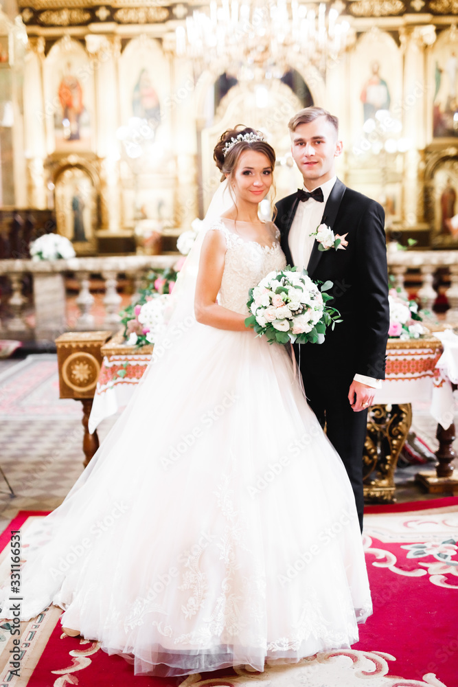 Naklejka premium Married couple posing in a church after ceremony