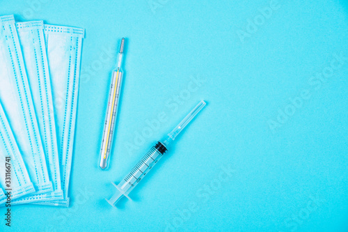 Disposable medical protective face mask, syringe and mercury thermometer. Concept of virus and flu or coronavirus