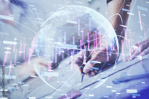 A woman hands writing information about stock market in notepad. Forex chart holograms in front. Concept of research. Double exposure