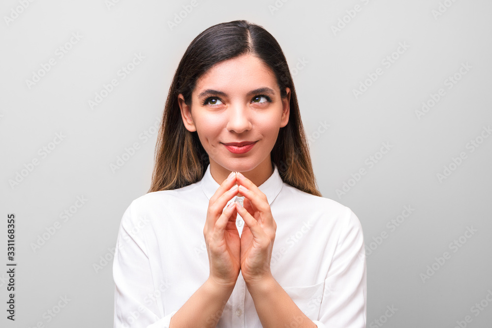 young sneaky woman, scheming something for april first, fools day against grey background young sneaky woman, scheming something for april first, fools day against grey background