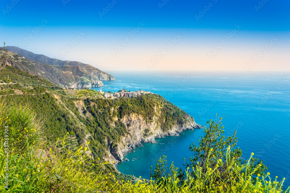 Corniglia, Cinque Terre - beautiful small village with colorful buildings on the cliff overlooking sea. Cinque Terre National Park with rugged coastline is famous tourist destination in Liguria, Italy