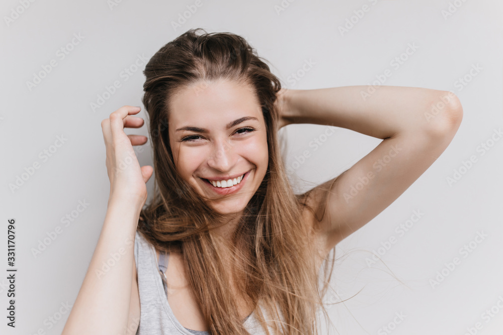 Joyful european woman laughing on white backgorund during photoshoot. Indoor photo of romantic girl expressing happiness.
