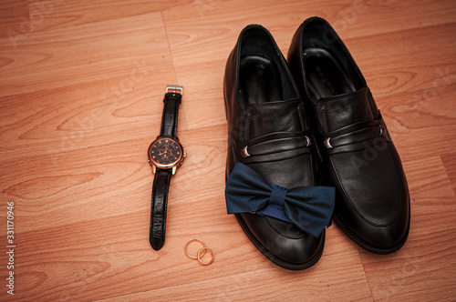 Shoes gold rings and wristwatch on the table