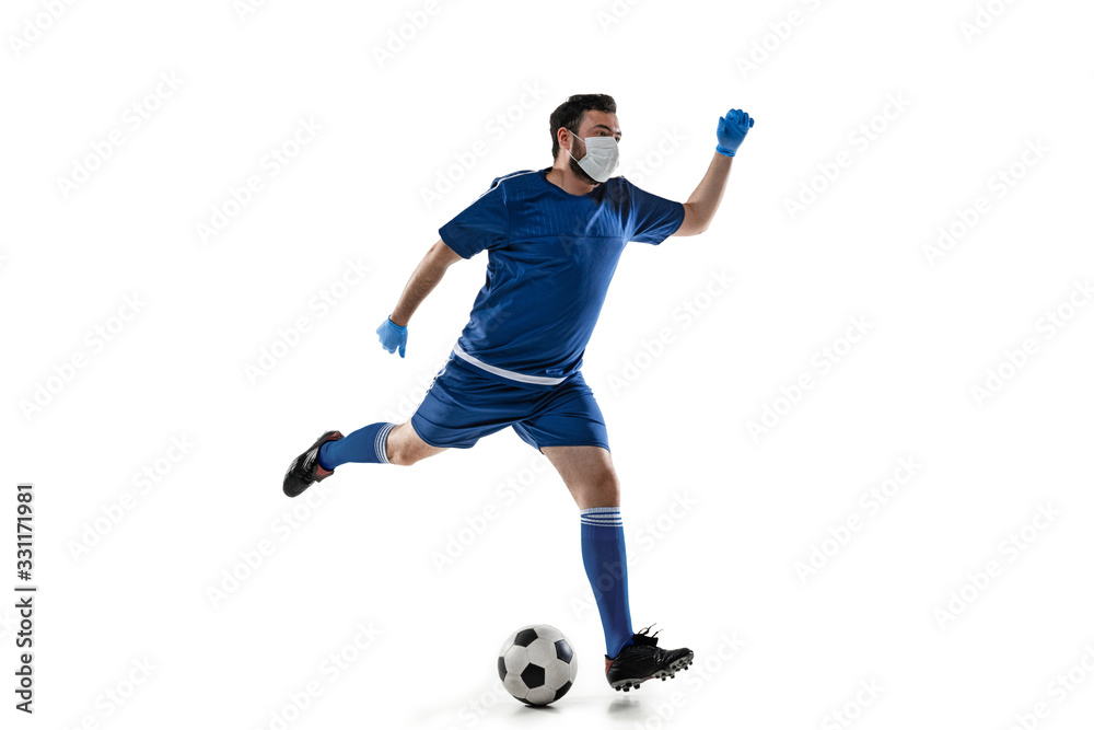 Obraz premium Beat the disease. Male football, soccer player in protective mask. Prevention against pneumonia. Still active while quarantine. Chinese coronavirus treatment. Healthcare, medicine, sport concept.