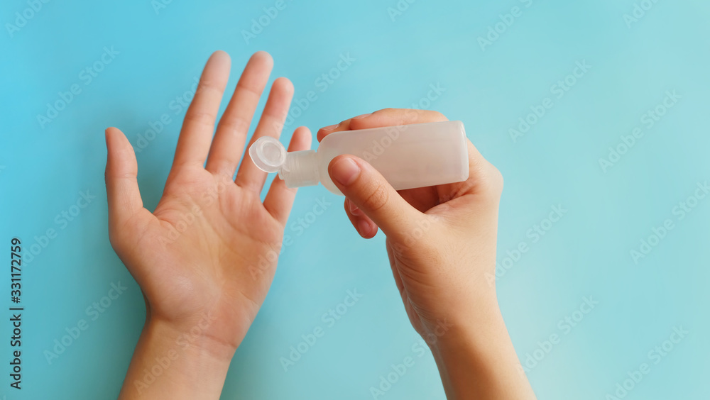 Hand holding a small travel size container and dripping the content into the other palm. Hand holding a small travel size container and dripping the content into the other palm.