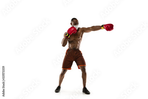 Beat the disease. Male african-american boxer in protective mask. Prevention against pneumonia. Still active while quarantine. Chinese coronavirus treatment. Healthcare, medicine, sport concept. © master1305