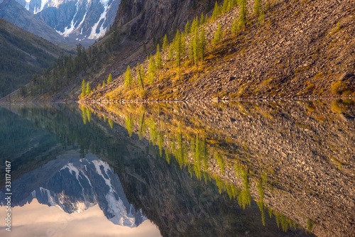 Reflections of mountains in the lake. Mountain valley and snowy mountains.