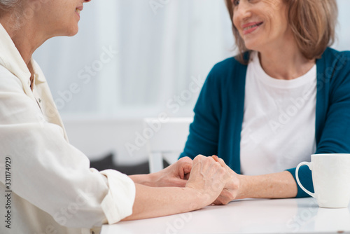 Mature women holding hands together