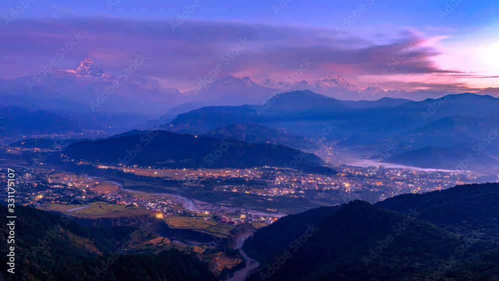 View of the Pokhara and Himalayan mountains from Sarangkot hill at twilight, Pokhara, Nepal.