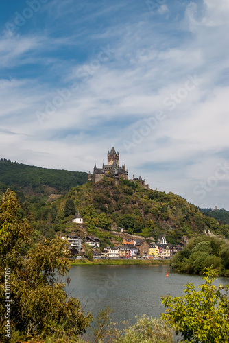 View of Reichsburg castle of Cochem with a amazing sky of background. It is can be found in the city of Cochem. The castle is set on a green hill overlooking the River Moselle. © Plamen Petrov
