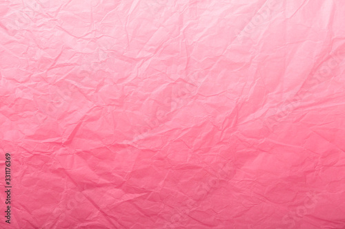 Texture of crumpled dark red wrapping paper with white gradient, closeup. Light pink old background.