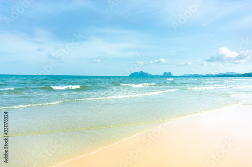 Clean white beach golden brown sand and small wave from blue sea under clear blue sky in a sunny day
