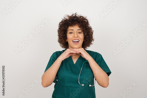 Pretty surprised young doctor woman fooling around in studio and jumping.