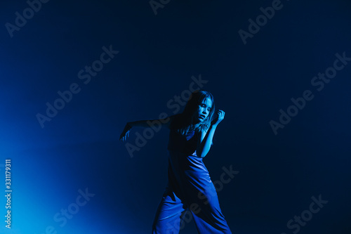 Young stylish girl dancing in the Studio on a colored neon background. Classic dancer.