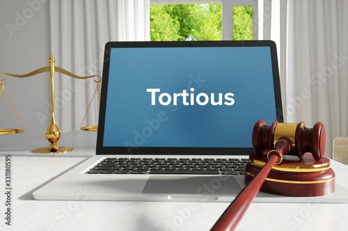 Tortious – Law, Judgment, Web. Laptop in the office with term on the screen. Hammer, Libra, Lawyer. photo