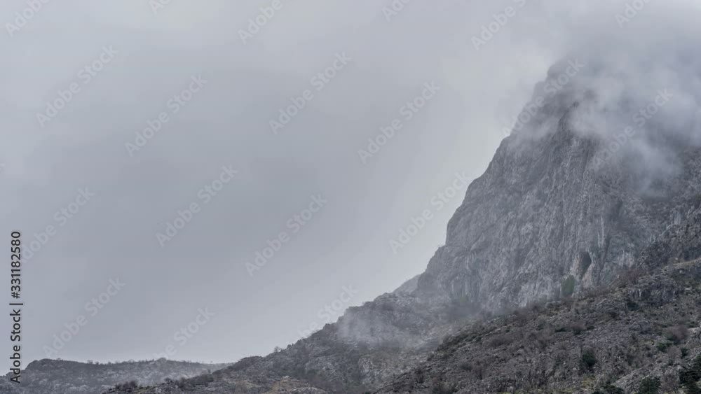 fog floats over the mountains , a rock appears , a timelapse fog floats over the mountains , a rock appears , a timelapse