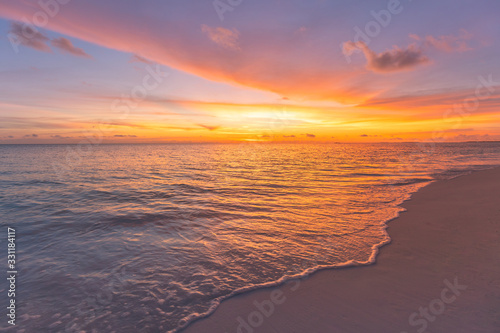 Closeup of sand on beach and blue summer sky. Panoramic beach landscape. Empty tropical beach and seascape. Orange and golden sunset sky, soft sand, calmness, tranquil relaxing sunlight, summer mood photo