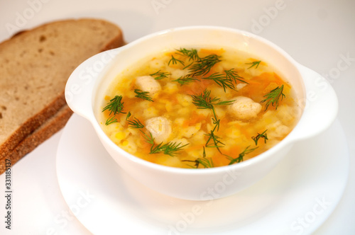 Chicken soup with meatballs and pasta on the table