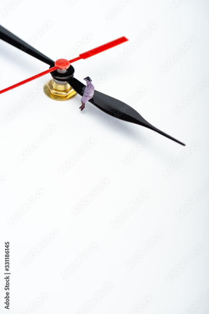 High angle view of people figure on pointer of clock on white surface with copy space, concept of aging High angle view of people figure on pointer of clock on white surface with copy space, concept of aging