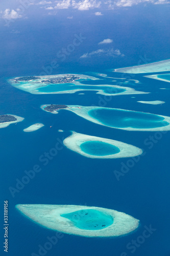 Maldives aerial view with atolls and islands. Amazing view from seaplane or drone, luxury vacation travel scenery