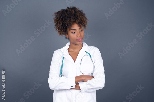 Closeup portrait displeased pissed off angry grumpy pessimistic doctor woman with bad attitude, arms crossed looking sideways. Negative human emotion facial expression feelings