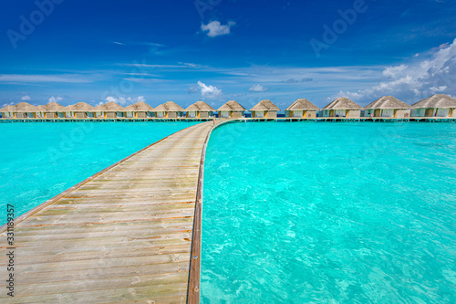 Maldives beach resort panoramic landscape. Amazing summer landscape with lagoon  blue sea and wooden jetty to water bungalows. Luxury vacation and travel landscape background
