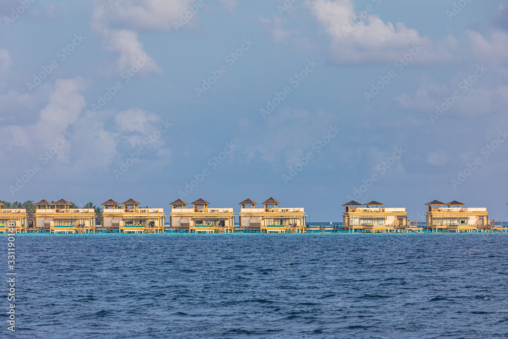 Panorama of Water Villas or bungalows and wooden bridge at Tropical beach in the Maldives at summer day