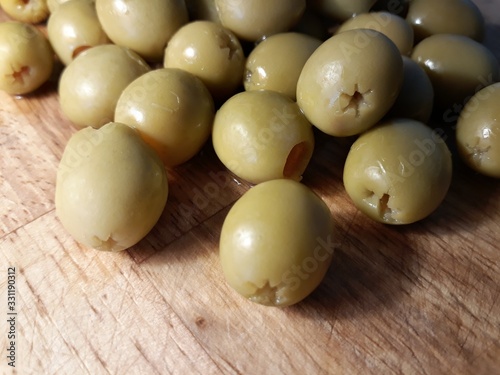 Green olives on a chopping wooden board