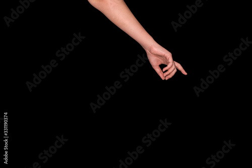 hand on a black background pointing to something in the center. The concept of ordering something, different things. indicate discount or item