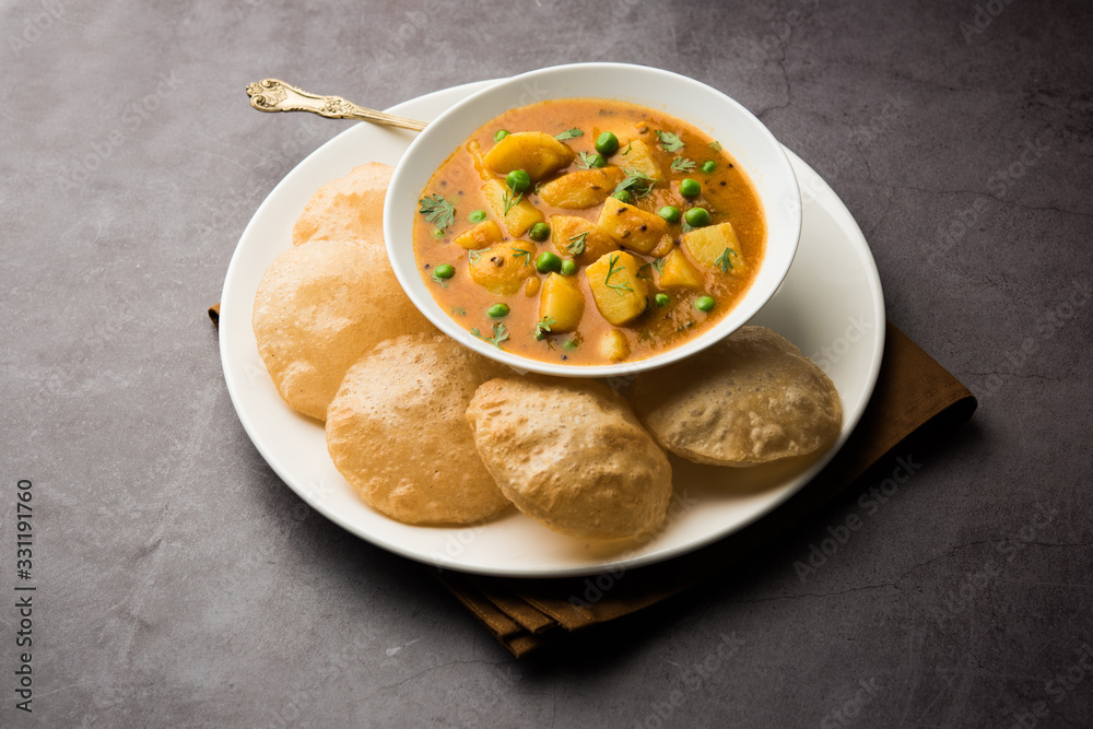 Aloo Puri or Potato curry with fried Poori, popular Indian breakfast / lunch / dinner menu. Aloo Puri or Potato curry with fried Poori, popular Indian breakfast / lunch / dinner menu.