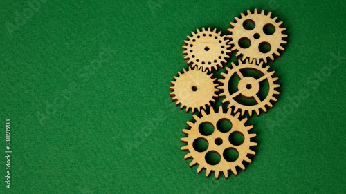 five wooden gears on a green background