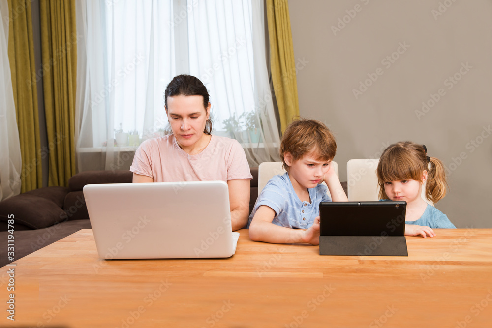 quarantine. Corona Virus. Mom Work on the Internet on a laptop and kids study online at home. quarantine. Corona Virus. Mom Work on the Internet on a laptop and kids study online at home.