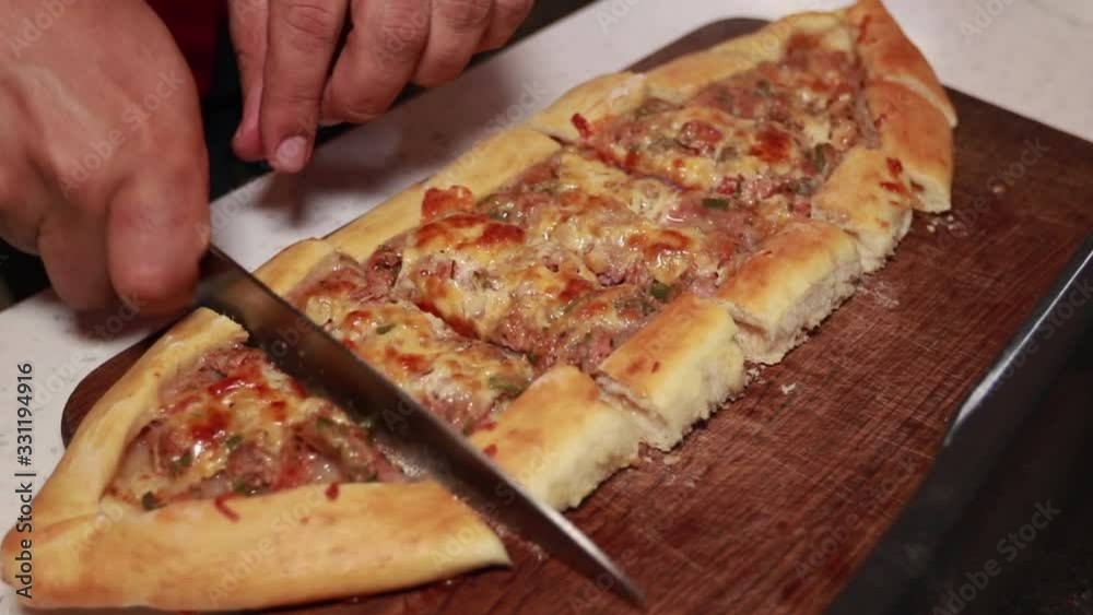 Chef lays Turkish pide on a wooden board Chef lays Turkish pide on a wooden board