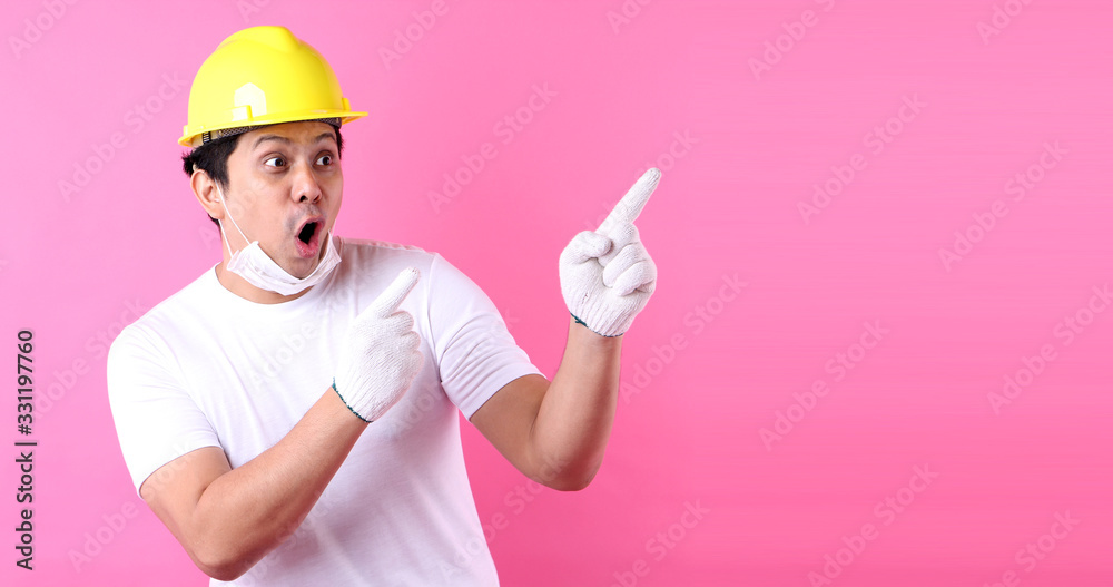 Asian man Industry worker or engineer working an architect builder Happy excited raising his fists  on pink background in studio With copy space,concept international labour day.