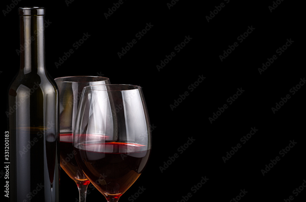 two glasses and bottle with red wine on black two glasses and bottle with red wine on black